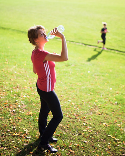 Eine Studentin pausiert am Sportfeldrand nach einem Training.