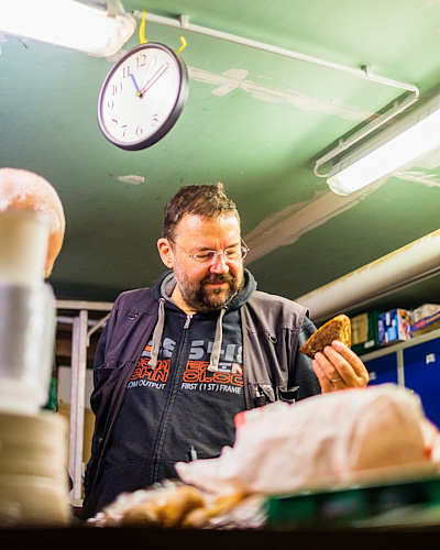 Portrait eines Mannes, der liebevoll ein Brötchen vor der Warenauslieferung begutachtet.