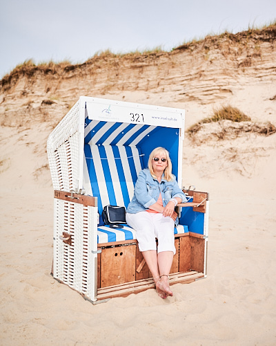 Umgebungsportrait von einer Frau in einem Strandkorb auf Sylt.