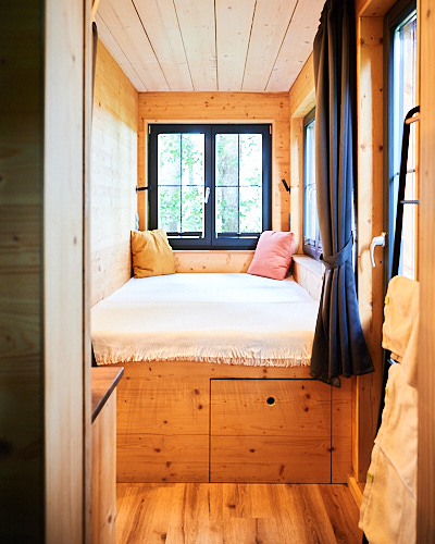 Fotografie einer gemütlichen Schlafkammer in einem Tinyhaus.