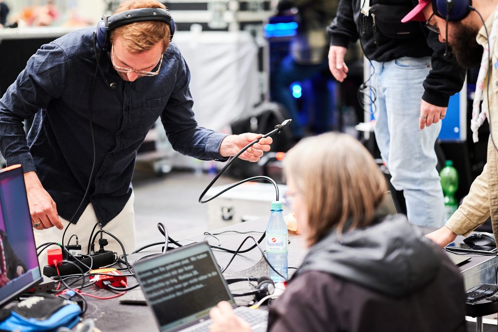 Veranstaltungsfototgrafie von einem Techniker, der ein Kabel umsteckt.