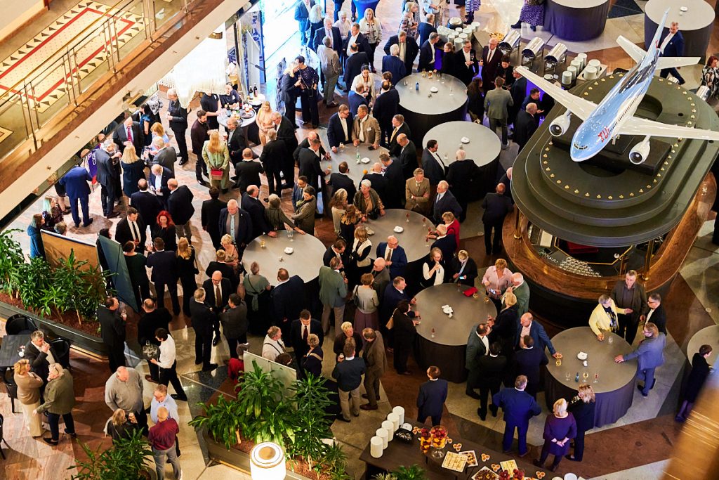 Mitglieder einer Jahrestagung versammeln sich während eines Events in einem Foyer.